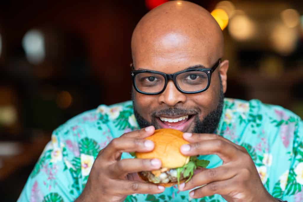 Amos Cooper Jr. eating a burger at Alley Twenty Six