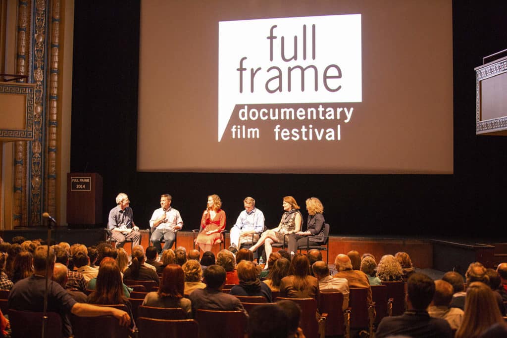 Several people on stage at the Carolina Theatre discussing a film.