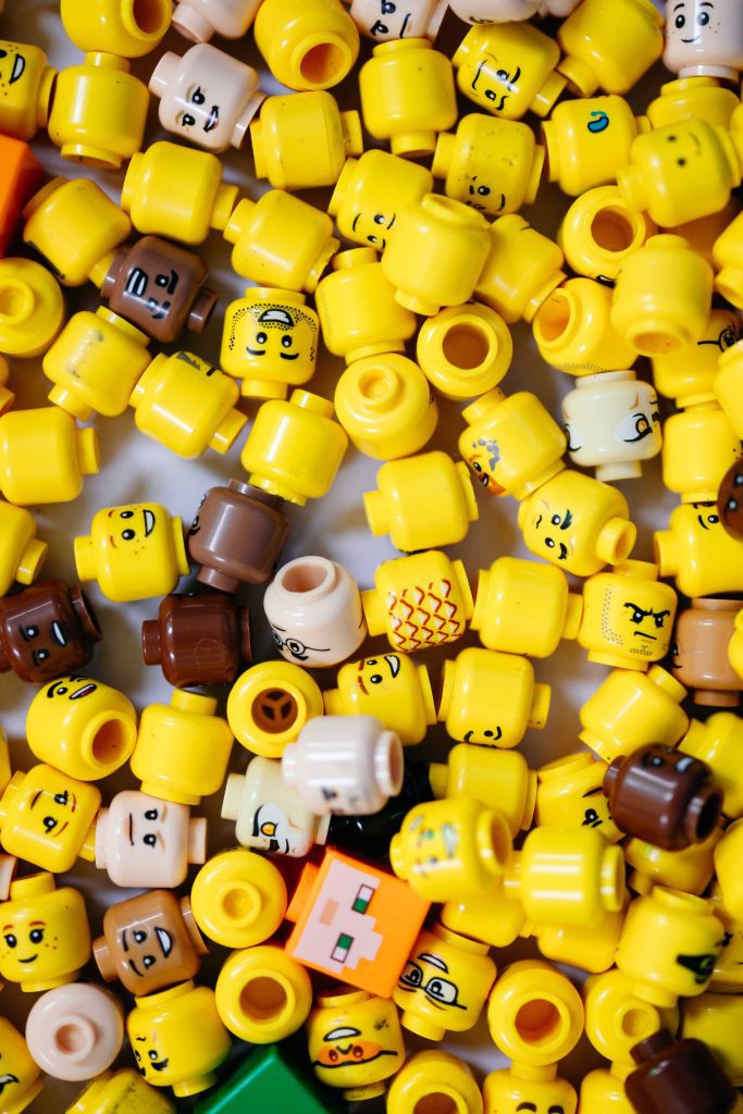 A collection of LEGO minifigure heads showing a variety of facial expressions, including surprised, silly, and perplexed, arranged together.