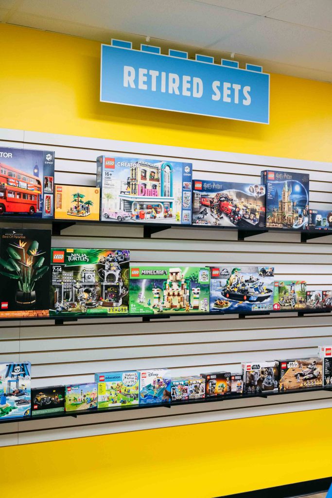 Shelves highlight used and retired LEGO sets no longer in production, alongside a selection of new sets.