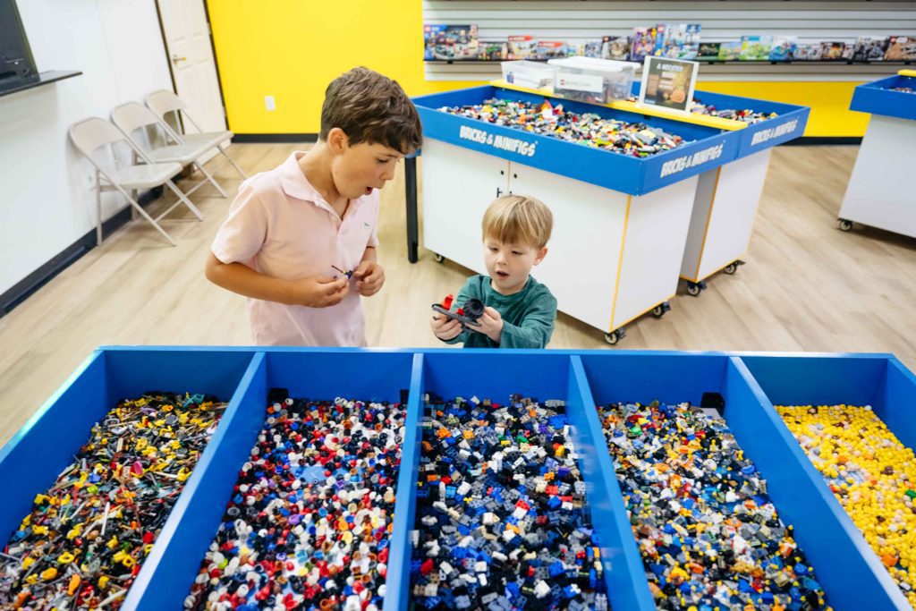 Lennox Gillis, 8, and Isaac Kamiya, 5, dig through bins of LEGO pieces as they build their own imaginative creations.