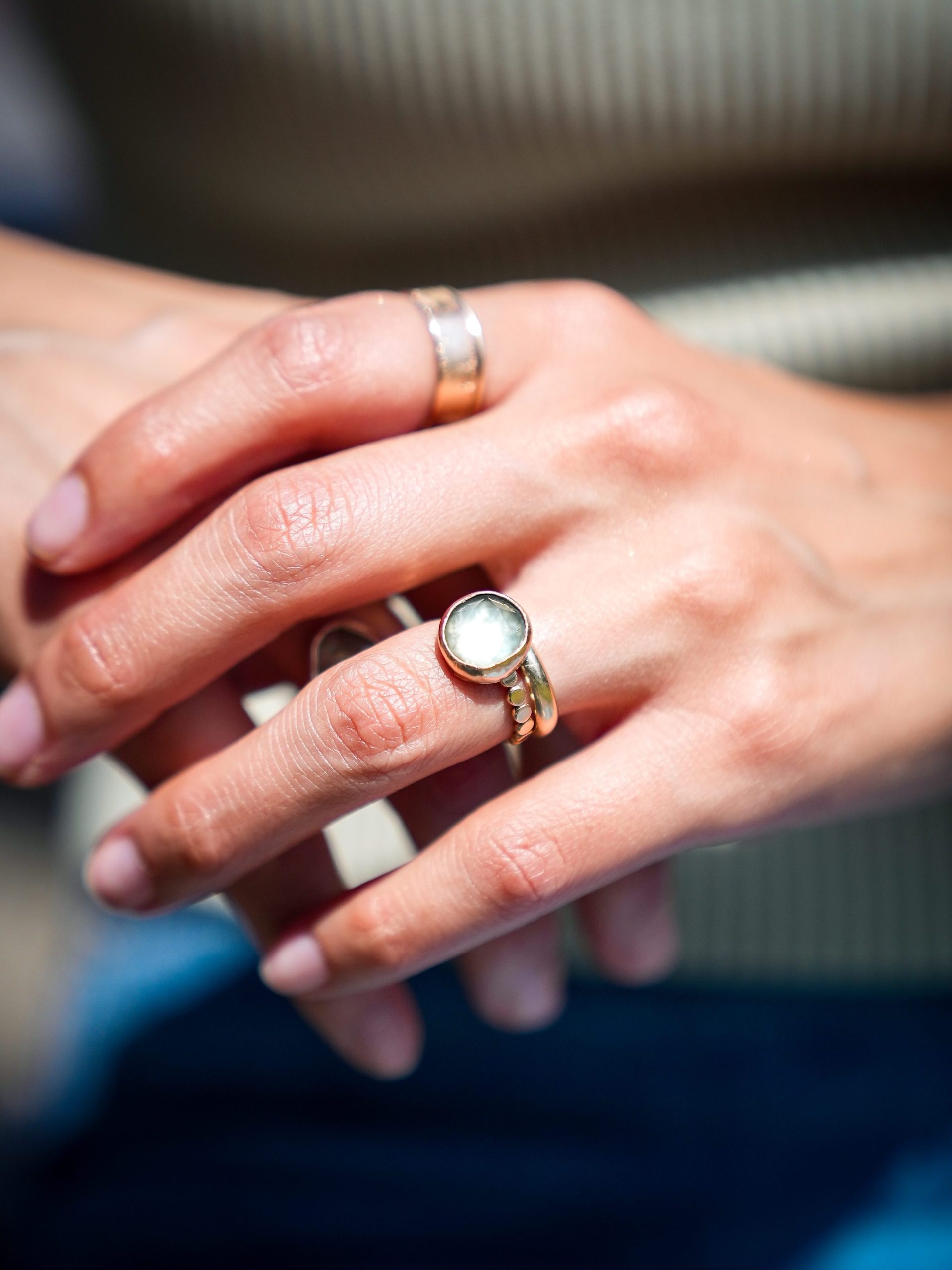 Daniela Cho's jewelry from the Luster Lab is displayed on a persons hands.