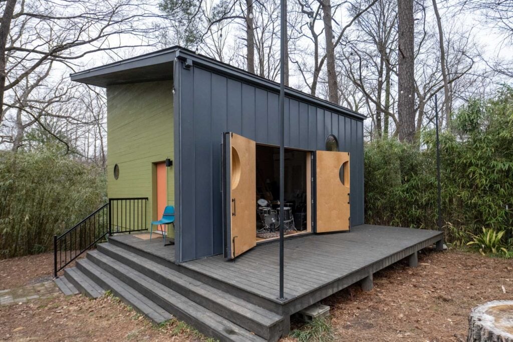 Backyard recording studio with large doors open onto a wooden deck.