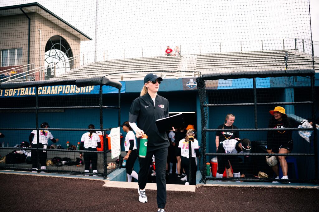 Head coach of Carolina Blaze softball team, Kara Dill walking on the field during the team's practice.