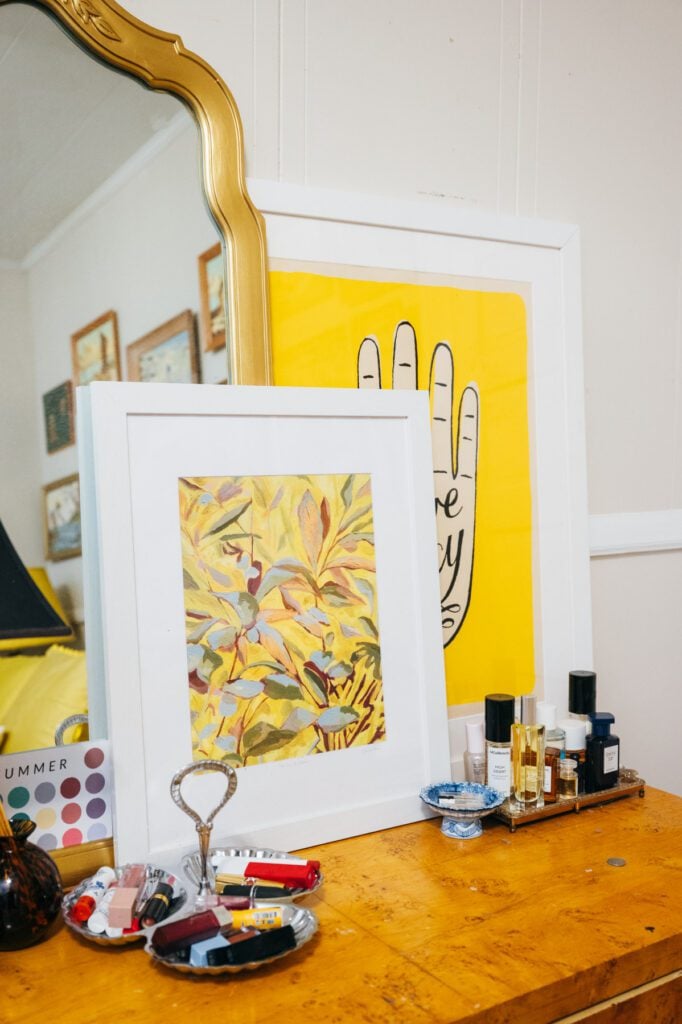 Framed artwork by Ellie Snow and collected objects sit atop a dresser, blending colorful modern accents with Courtney Hayes’ layered, collected style.