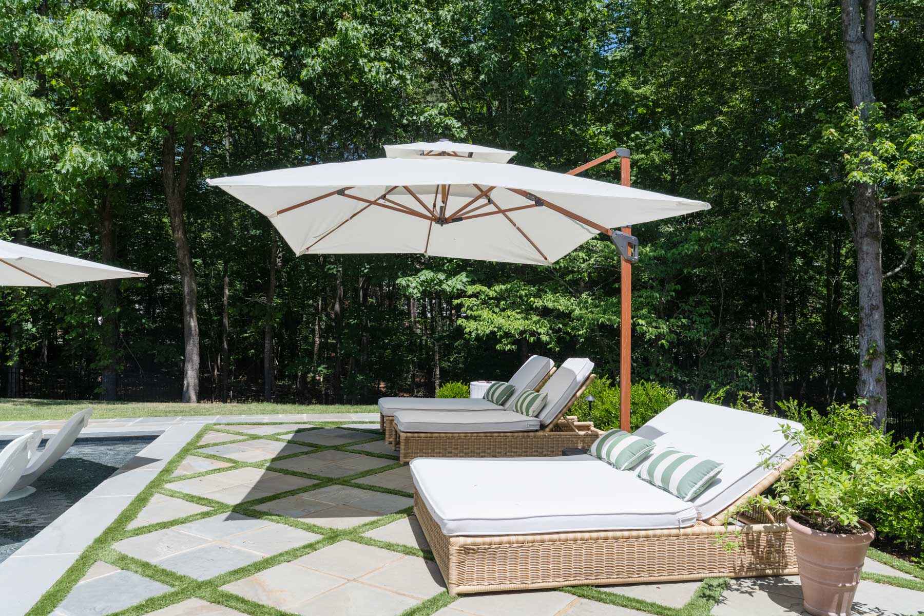 The poolside lounge chairs and paved poolside in the Serrano's back yard.