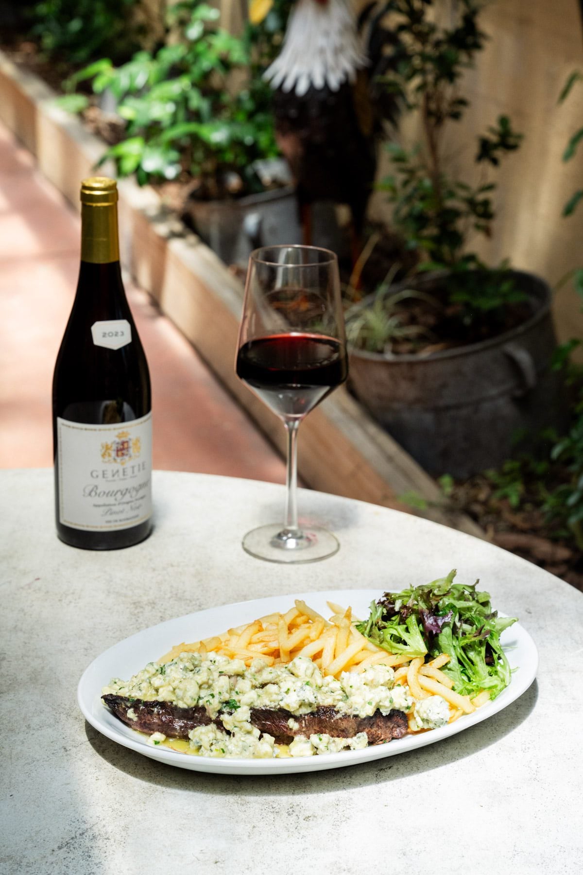 Steak with butter, French fries, salad and wine at Vin Rouge.