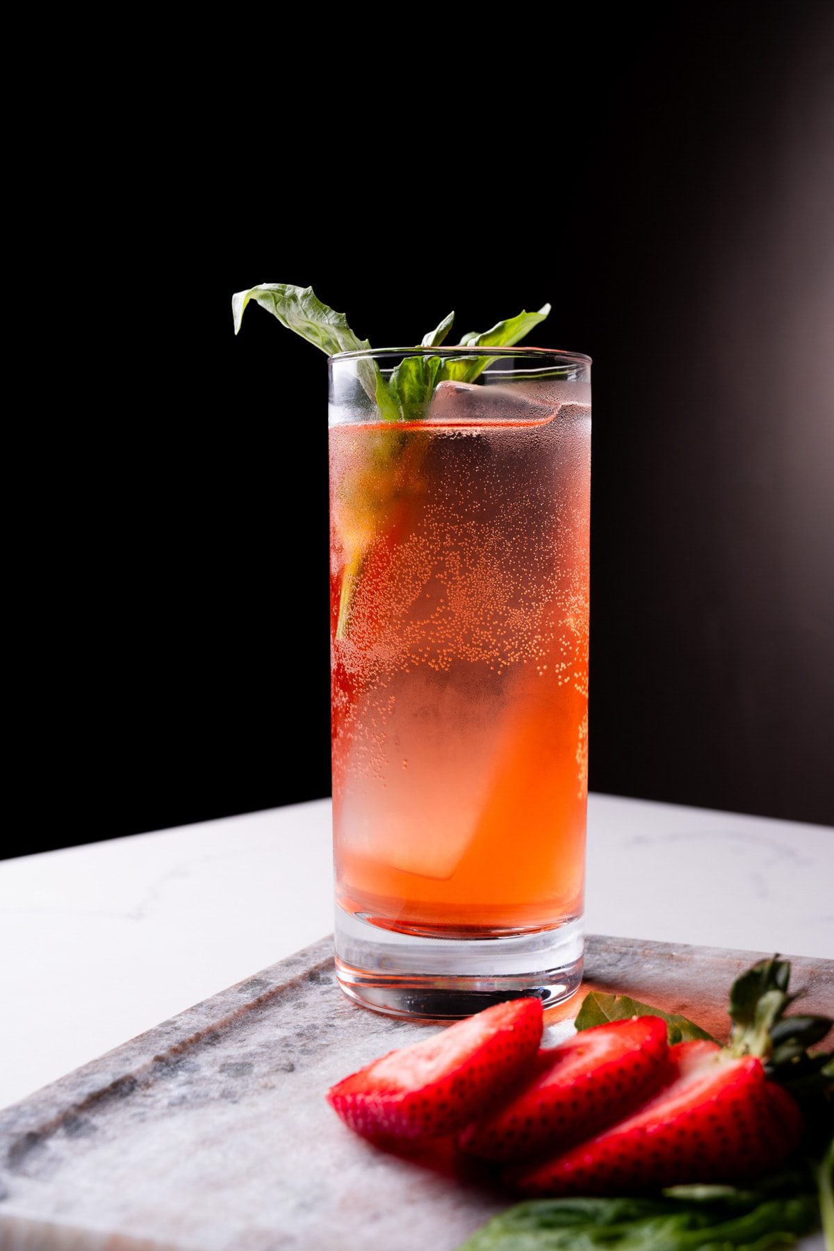 The Gin Basic Smash from Conniption Bar & Lounge sits with strawberries.