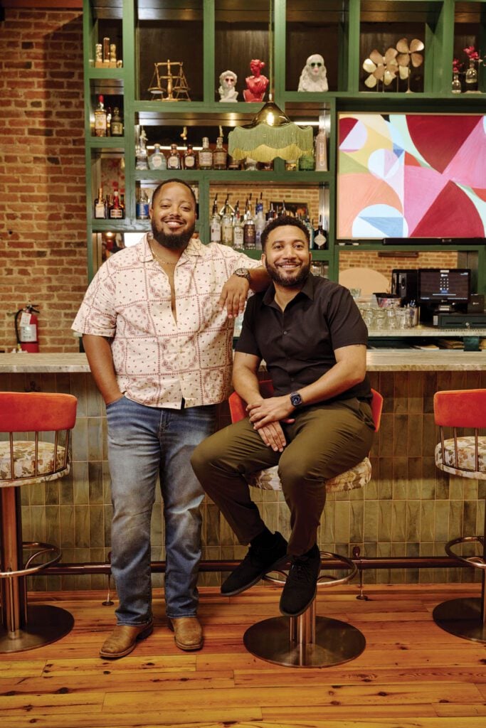 Owners of Primrose Bar & Lounge Mike Douglas and Darryl Coleman smile for a photo inside their bar. 