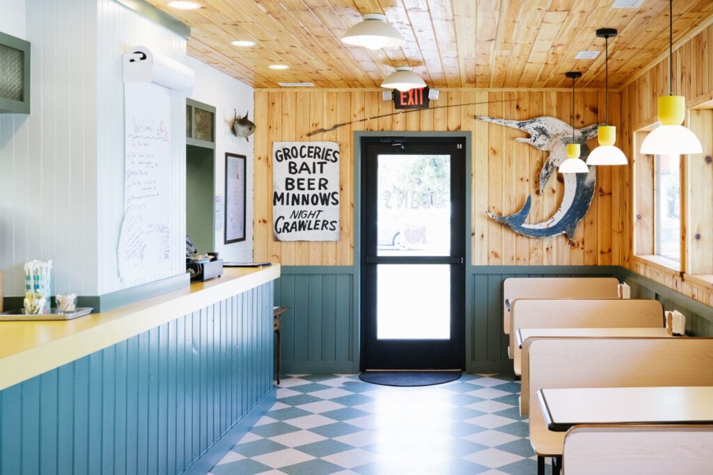 Interior of The Barj at Jean's "By the Sea" in Durham features wood-paneled walls, blue counters and checkered floors.