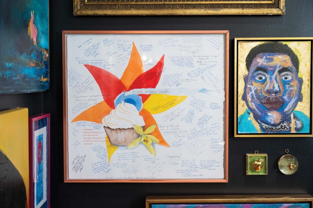 Colorful original artwork creates a striking contrast against the dining area’s black walls.